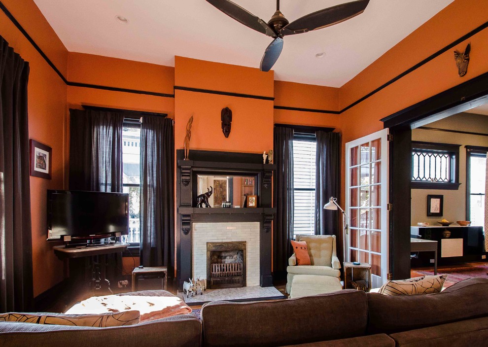 This is an example of a mid-sized traditional open concept family room in Atlanta with orange walls.