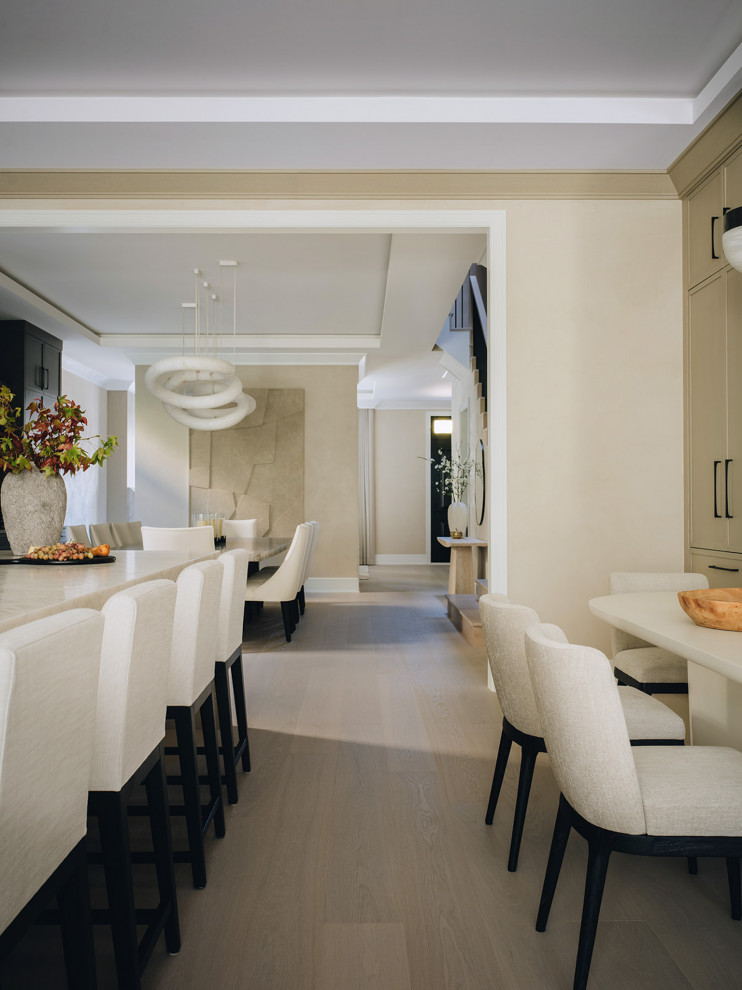 Transitional light wood floor and beige floor kitchen photo in Chicago with beige cabinets, quartzite countertops, stone slab backsplash, paneled appliances and an island
