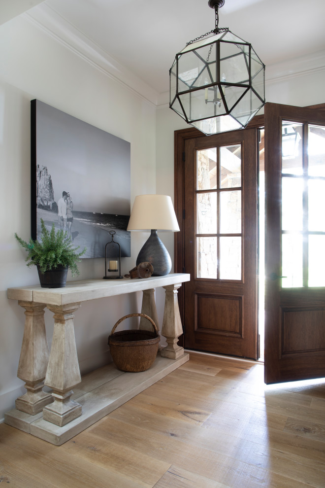 This is an example of a mid-sized country foyer in Atlanta with white walls, light hardwood floors, a double front door, a dark wood front door and beige floor.