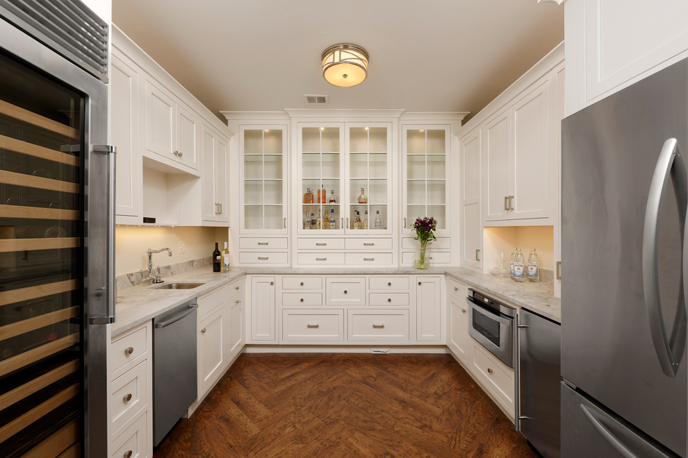 Kitchen pantry - large transitional u-shaped medium tone wood floor and brown floor kitchen pantry idea in DC Metro with an undermount sink, recessed-panel cabinets, white cabinets, marble countertops, white backsplash, marble backsplash and stainless steel appliances