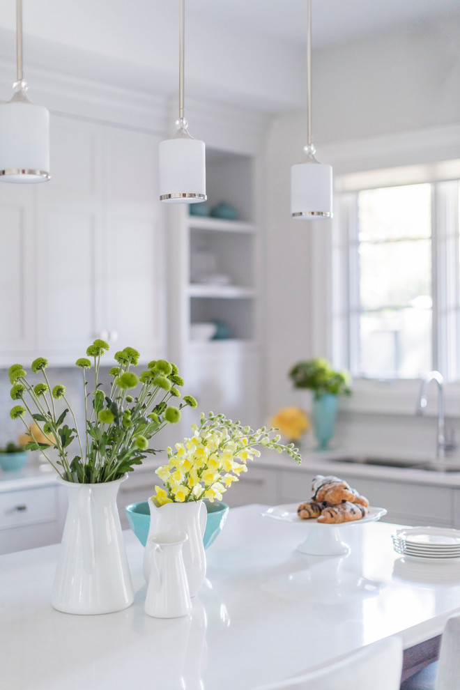Example of a transitional u-shaped medium tone wood floor eat-in kitchen design in Toronto with an undermount sink, recessed-panel cabinets, white cabinets, quartz countertops, white backsplash, stone tile backsplash, stainless steel appliances and an island