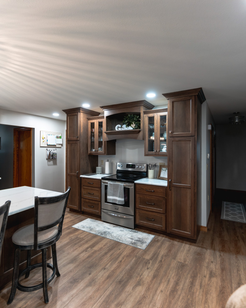 Design ideas for an expansive traditional l-shaped open plan kitchen in Other with shaker cabinets, medium wood cabinets, engineered stone countertops, stainless steel appliances, medium hardwood flooring, an island, brown floors and white worktops.