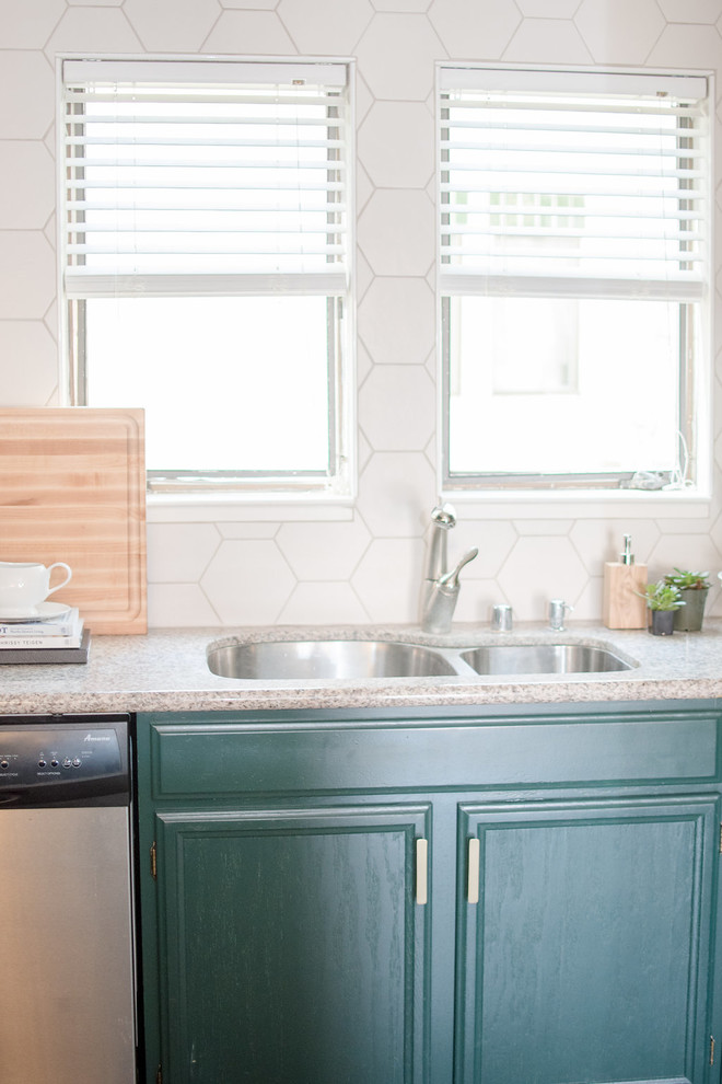 Open concept kitchen - small eclectic single-wall open concept kitchen idea in San Francisco with a double-bowl sink, recessed-panel cabinets, green cabinets, granite countertops, white backsplash, porcelain backsplash, stainless steel appliances and no island