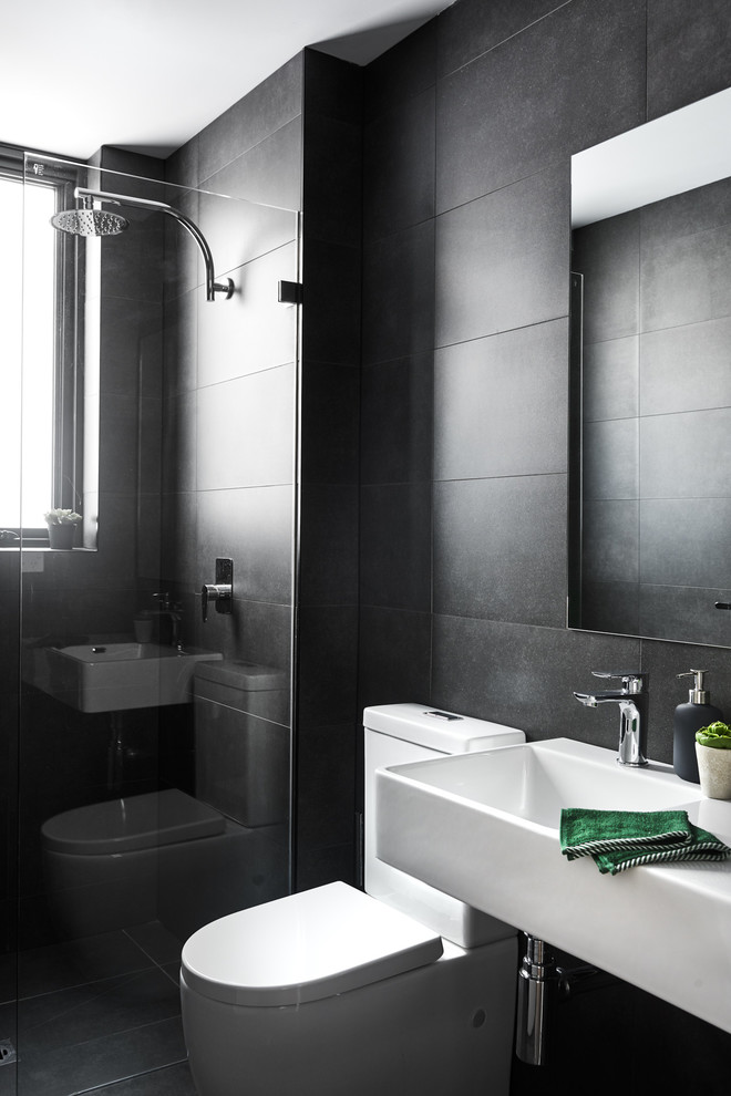 Small contemporary bathroom in Sydney with white cabinets, a corner shower, a one-piece toilet, white tile, porcelain tile, black walls, porcelain floors, a wall-mount sink, black floor and a hinged shower door.
