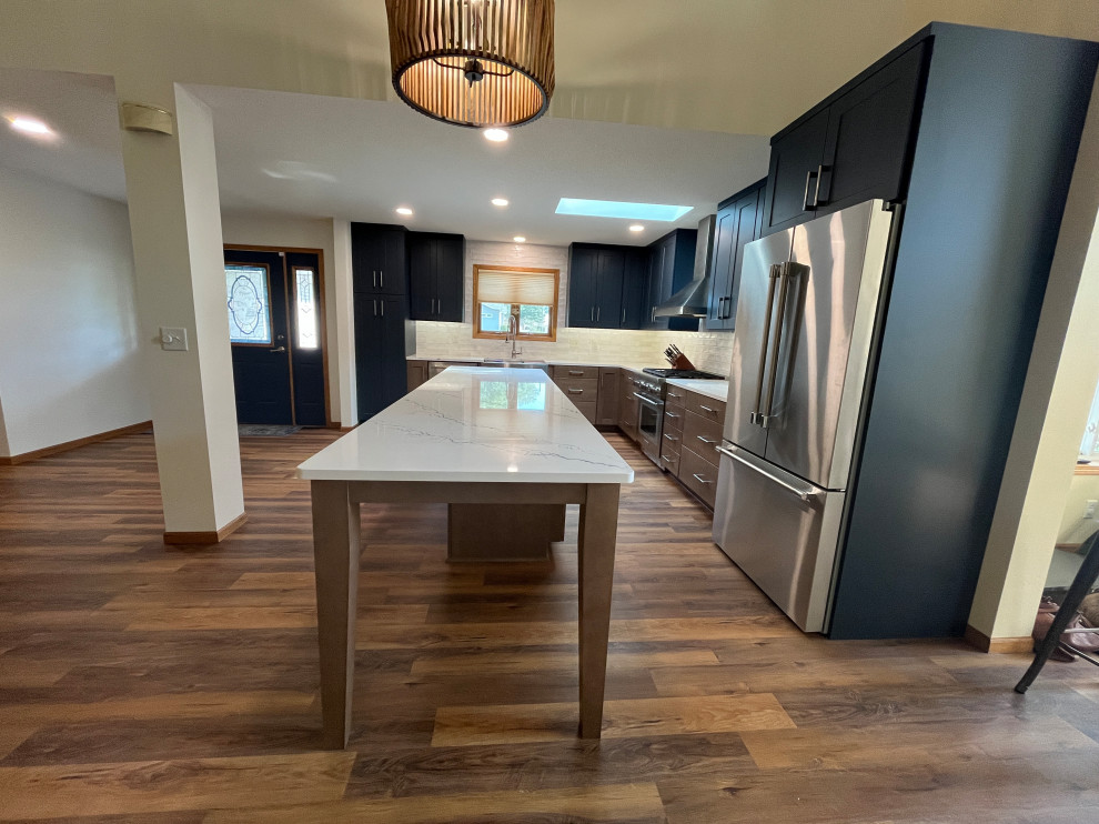 Large transitional l-shaped eat-in kitchen photo with shaker cabinets, quartz countertops and an island