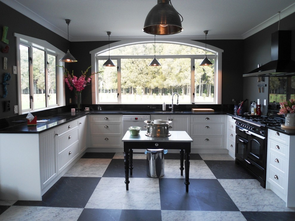 Inspiration for a large country u-shaped open plan kitchen in Hamilton with a double-bowl sink, shaker cabinets, white cabinets, granite benchtops, black splashback, glass sheet splashback, black appliances, slate floors, no island and white floor.