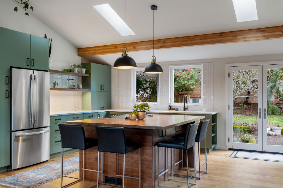 Foto di una cucina contemporanea con ante lisce, ante verdi, paraspruzzi bianco, elettrodomestici in acciaio inossidabile, parquet chiaro, pavimento beige, top bianco e soffitto a volta