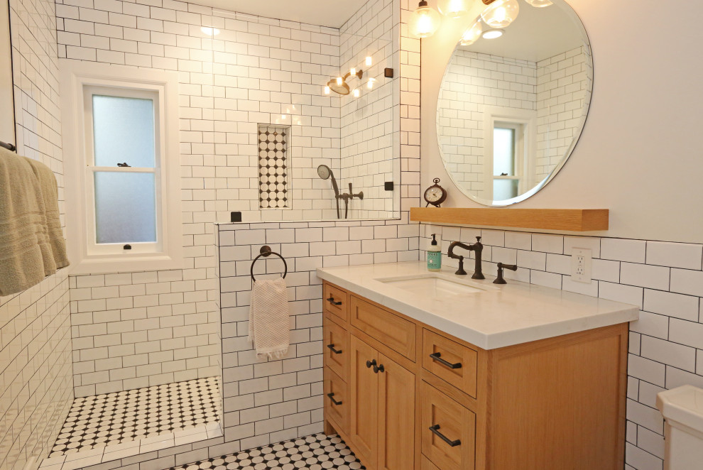 Idéer för mellanstora lantliga vitt badrum med dusch, med luckor med infälld panel, skåp i ljust trä, en dusch i en alkov, en toalettstol med hel cisternkåpa, vit kakel, cementkakel, beige väggar, klinkergolv i keramik, ett nedsänkt handfat, marmorbänkskiva, flerfärgat golv och med dusch som är öppen
