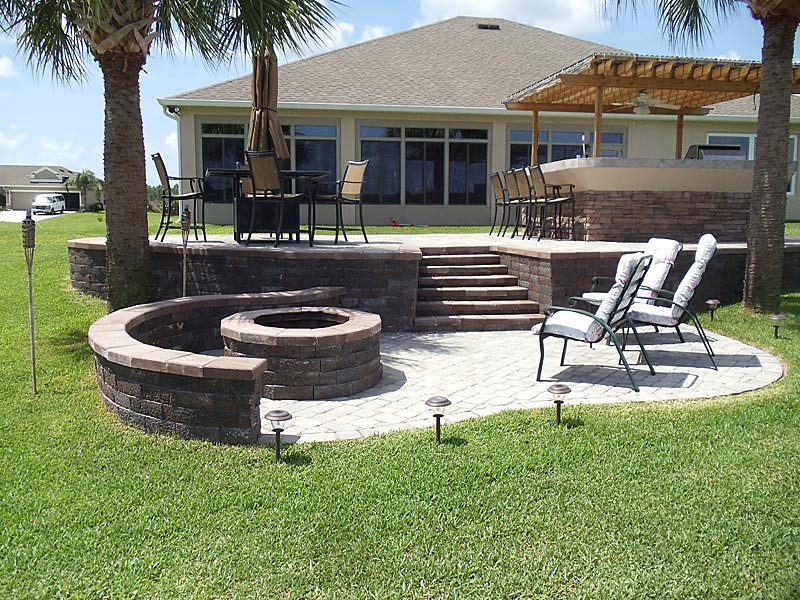 Mid-sized traditional backyard patio in Tampa with an outdoor kitchen, stamped concrete and a pergola.