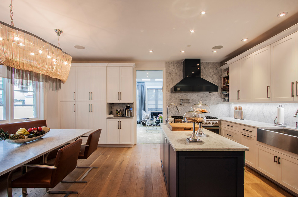 Contemporary l-shaped eat-in kitchen in New York with a farmhouse sink, white cabinets, shaker cabinets and grey splashback.