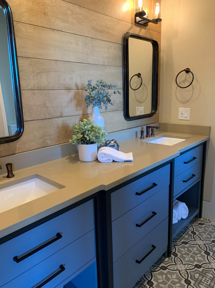 Design ideas for a mid-sized country kids bathroom in Tampa with flat-panel cabinets, blue cabinets, a one-piece toilet, beige walls, porcelain floors, an undermount sink, engineered quartz benchtops, multi-coloured floor, a hinged shower door and beige benchtops.