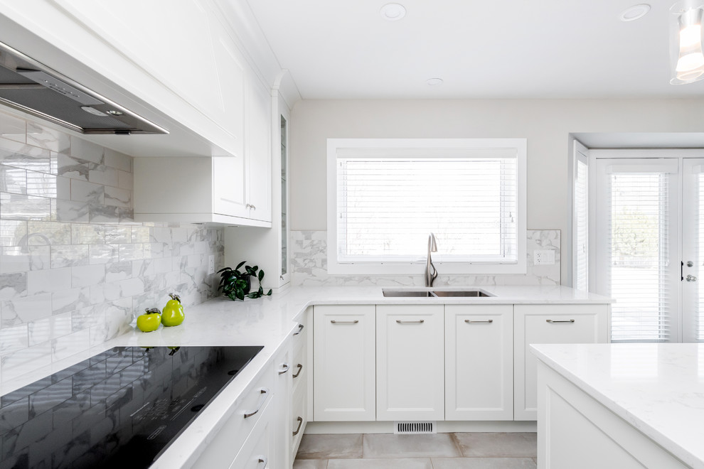 Eat-in kitchen - mid-sized transitional u-shaped porcelain tile and beige floor eat-in kitchen idea in Edmonton with a double-bowl sink, shaker cabinets, white cabinets, quartz countertops, multicolored backsplash, subway tile backsplash, stainless steel appliances, an island and white countertops
