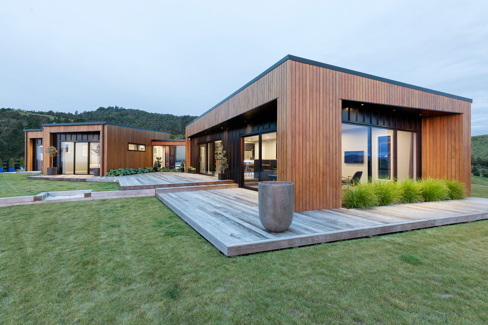 Inspiration for a contemporary one-storey brown house exterior in Other with wood siding and a flat roof.