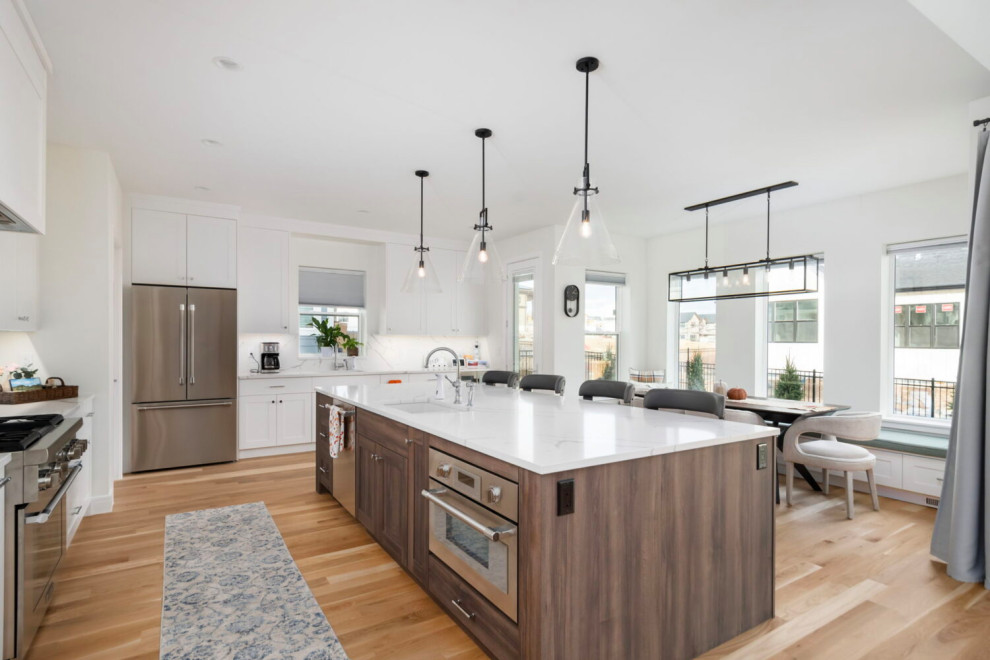 Large transitional l-shaped medium tone wood floor, brown floor and coffered ceiling open concept kitchen photo in Austin with an undermount sink, beaded inset cabinets, white cabinets, quartz countertops, white backsplash, quartz backsplash, stainless steel appliances, an island and white countertops