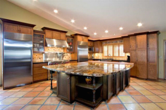 Transitional l-shaped medium tone wood floor kitchen pantry photo in Phoenix with raised-panel cabinets, medium tone wood cabinets, wood countertops, multicolored backsplash, ceramic backsplash and an island