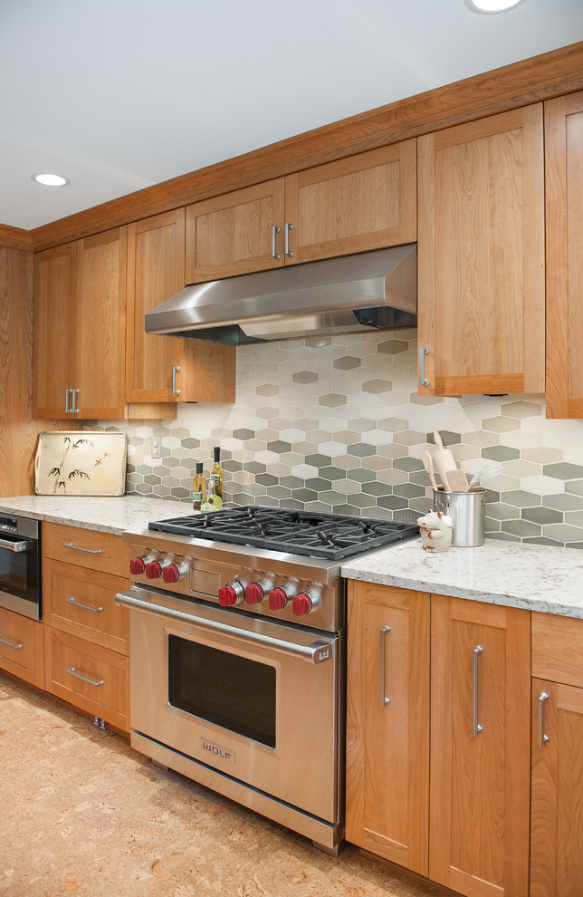 Inspiration for a large transitional l-shaped cork floor eat-in kitchen remodel in Portland with a single-bowl sink, recessed-panel cabinets, medium tone wood cabinets, quartz countertops, beige backsplash, ceramic backsplash, stainless steel appliances and an island