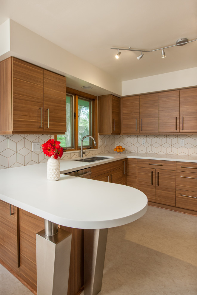 Mid-sized contemporary u-shaped eat-in kitchen in Minneapolis with an undermount sink, flat-panel cabinets, medium wood cabinets, solid surface benchtops, white splashback, ceramic splashback, stainless steel appliances, vinyl floors and a peninsula.