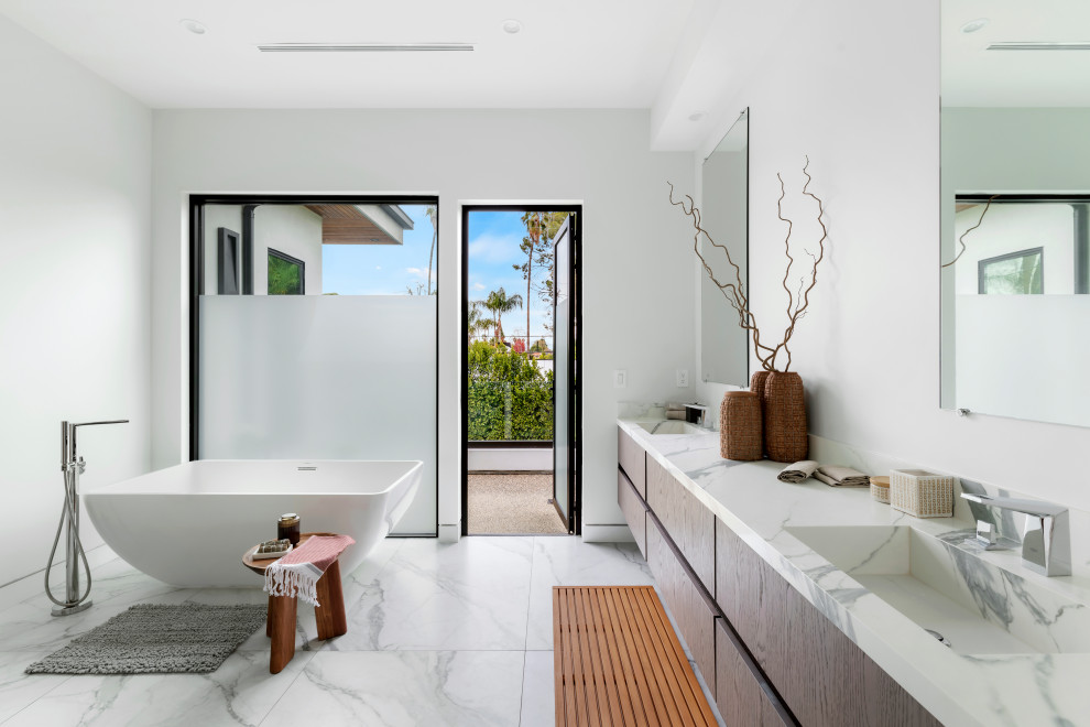 Inspiration for a mid-sized contemporary master bathroom in Los Angeles with flat-panel cabinets, dark wood cabinets, a freestanding tub, white walls, an integrated sink, a double vanity, a floating vanity, marble floors, marble benchtops, a niche, mirror tile, multi-coloured floor and multi-coloured benchtops.