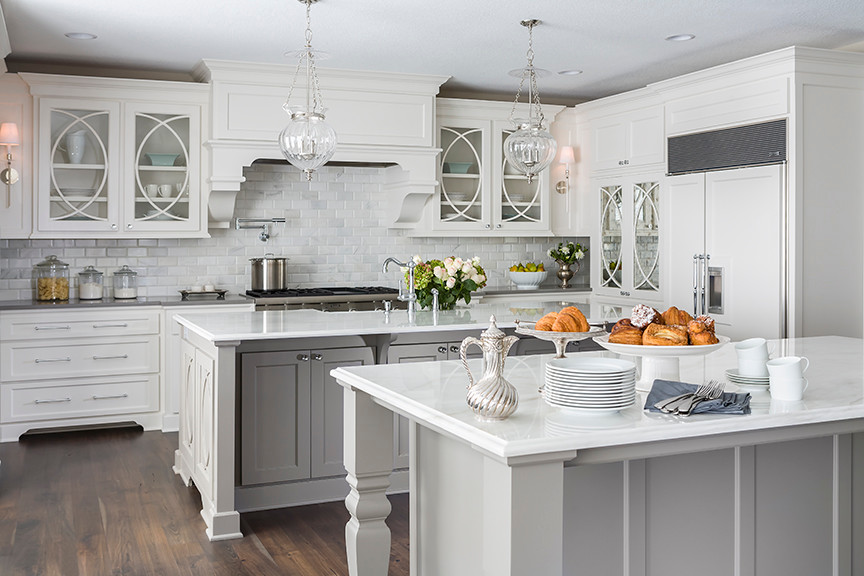 Large transitional u-shaped dark wood floor eat-in kitchen photo in Minneapolis with an undermount sink, recessed-panel cabinets, gray cabinets, marble countertops, white backsplash, stone tile backsplash, paneled appliances and two islands