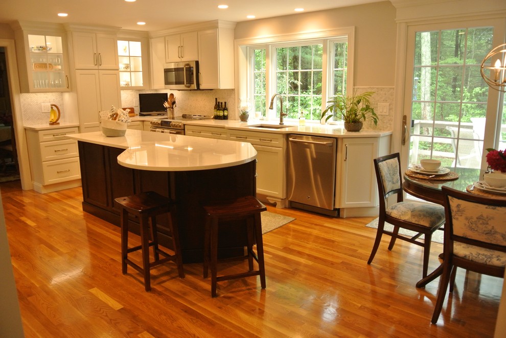Eat-in kitchen - transitional medium tone wood floor eat-in kitchen idea in Boston with an undermount sink, shaker cabinets, quartz countertops, beige backsplash, mosaic tile backsplash, stainless steel appliances, an island and white countertops