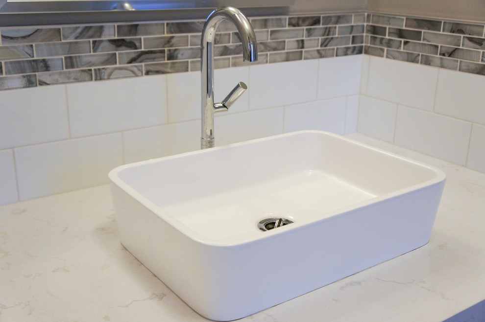 Immagine di un piccolo bagno di servizio minimal con lavabo a bacinella, ante in stile shaker, ante bianche, top in quarzo composito, piastrelle multicolore e WC monopezzo