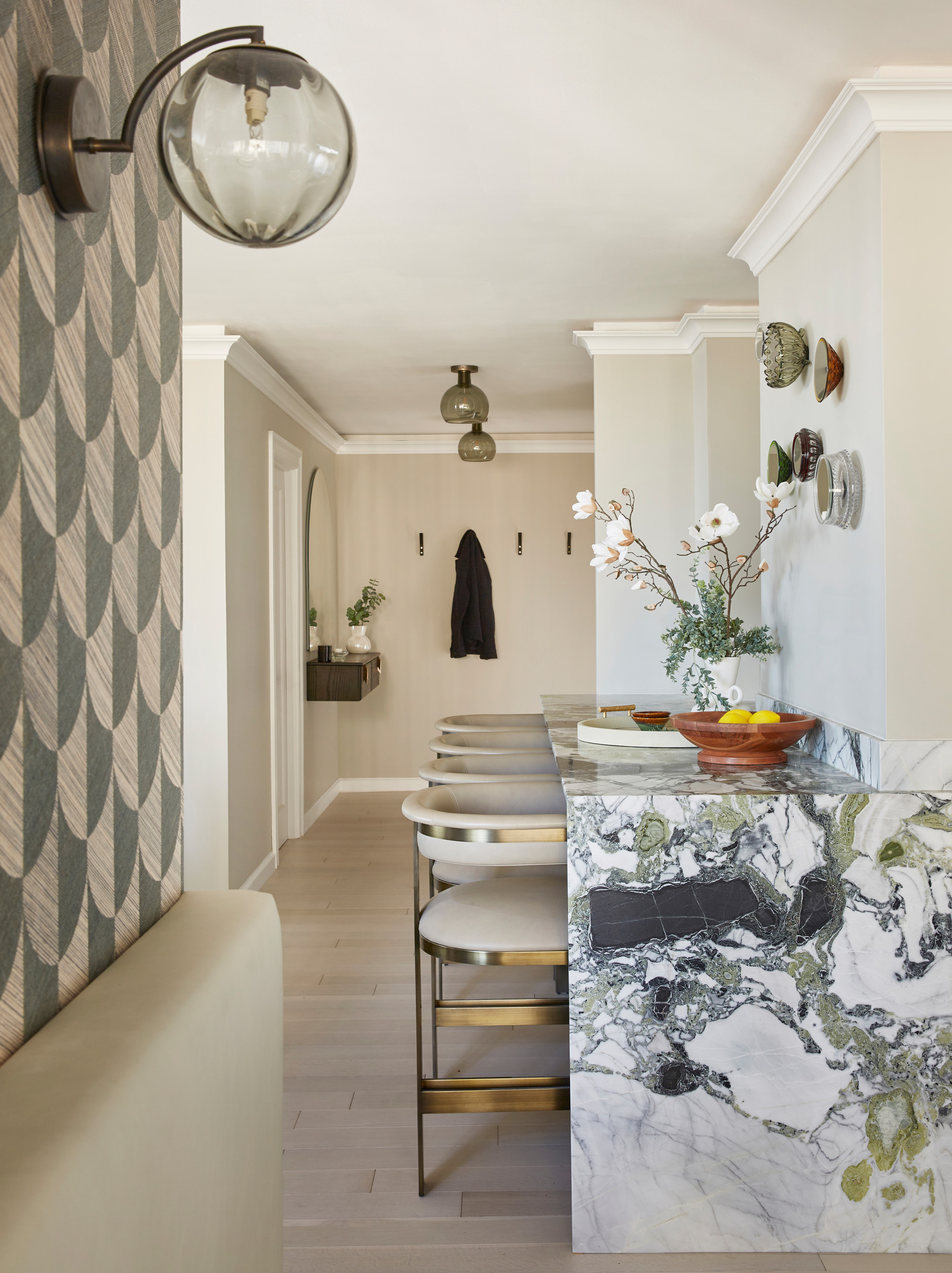 complete gut renovation to create open concept kitchen, panel ready refrigerator, mirrored italian bowl art piece, leather and brass counter stools, waterfall marble island, entry wood floating consol