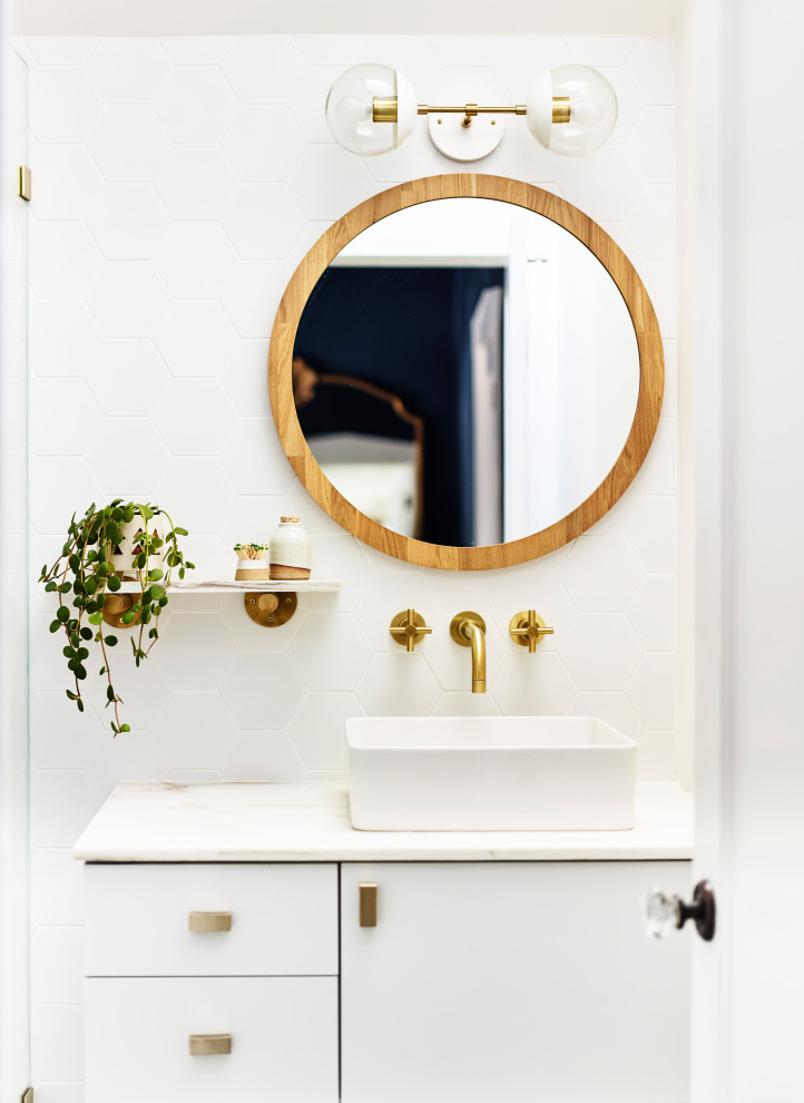 This is an example of a mid-sized scandinavian bathroom in San Francisco with black cabinets, white tile, porcelain tile, white walls, a vessel sink, marble benchtops and white benchtops.