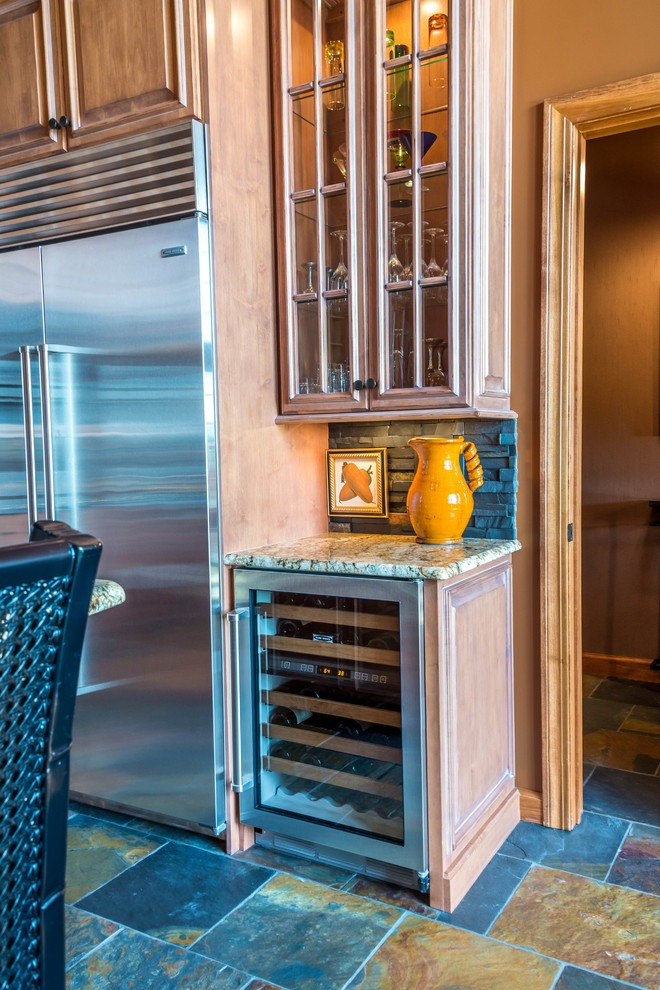 Open concept kitchen - small eclectic l-shaped slate floor open concept kitchen idea with an undermount sink, glass-front cabinets, light wood cabinets, granite countertops, black backsplash, stone tile backsplash, stainless steel appliances and an island