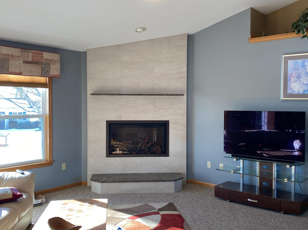 Mittelgroßes, Abgetrenntes Modernes Wohnzimmer mit blauer Wandfarbe, Teppichboden, Hängekamin, gefliester Kaminumrandung und gewölbter Decke in Sonstige