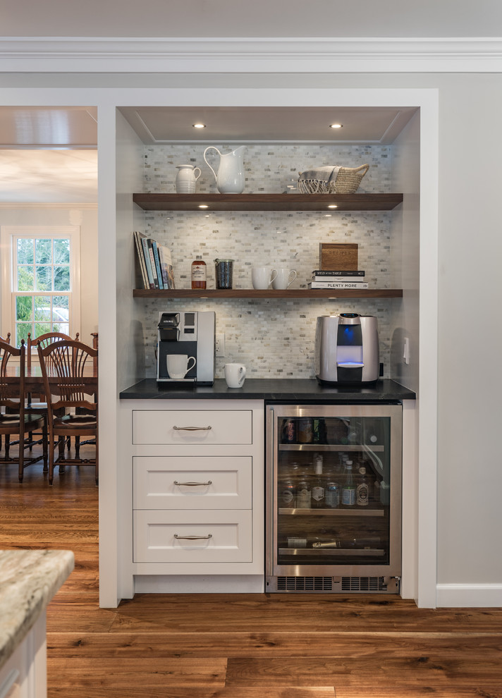 This is an example of a mid-sized transitional l-shaped separate kitchen in Boston with an integrated sink, recessed-panel cabinets, white cabinets, soapstone benchtops, multi-coloured splashback, porcelain splashback, stainless steel appliances, dark hardwood floors, with island and brown floor.