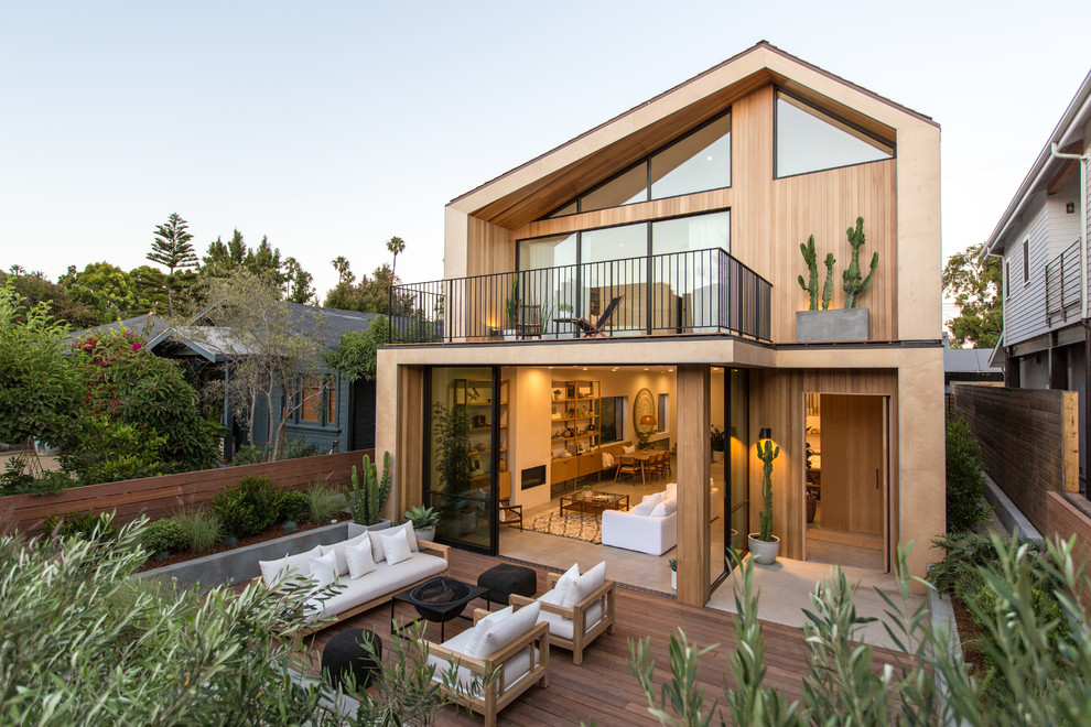 Design ideas for a contemporary two-storey beige house exterior in Los Angeles with wood siding.