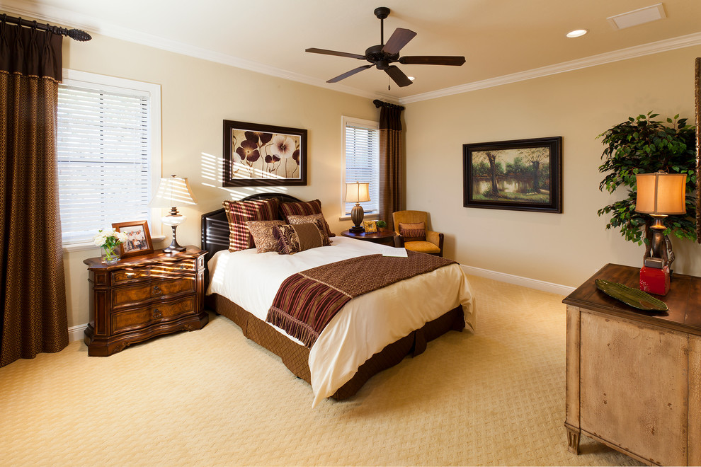 Photo of a large traditional master bedroom in Tampa with beige walls and carpet.