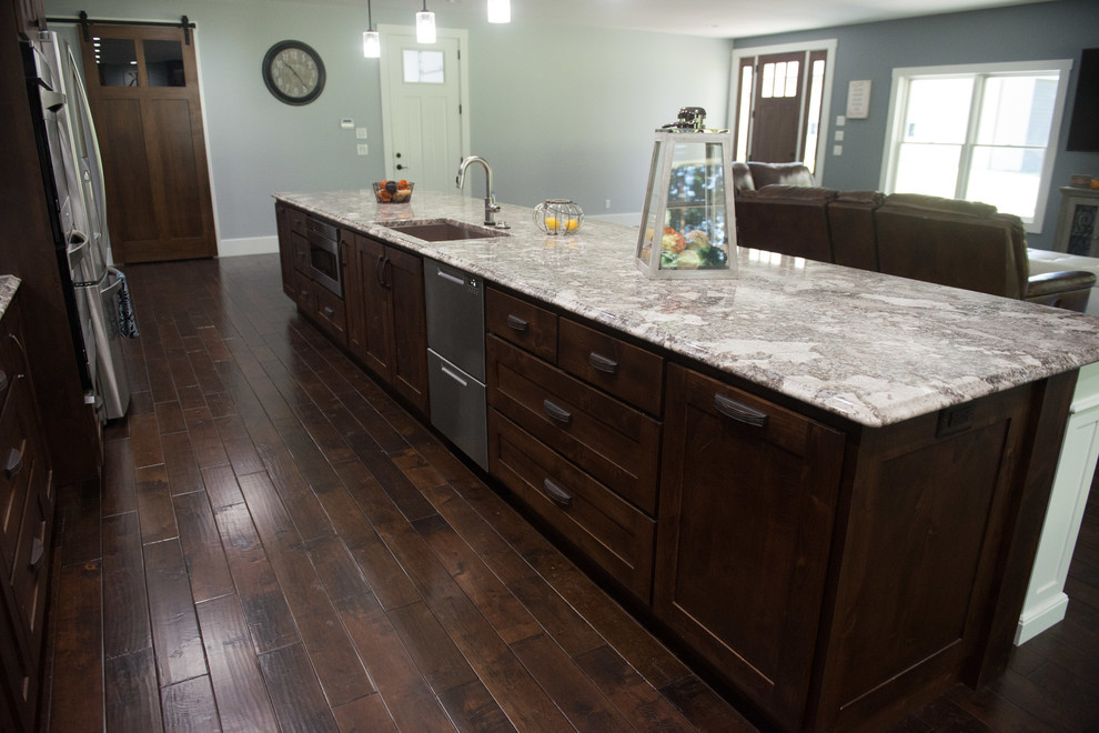 Inspiration for a transitional l-shaped open concept kitchen remodel with an undermount sink, shaker cabinets, dark wood cabinets, granite countertops, stainless steel appliances, an island and multicolored countertops