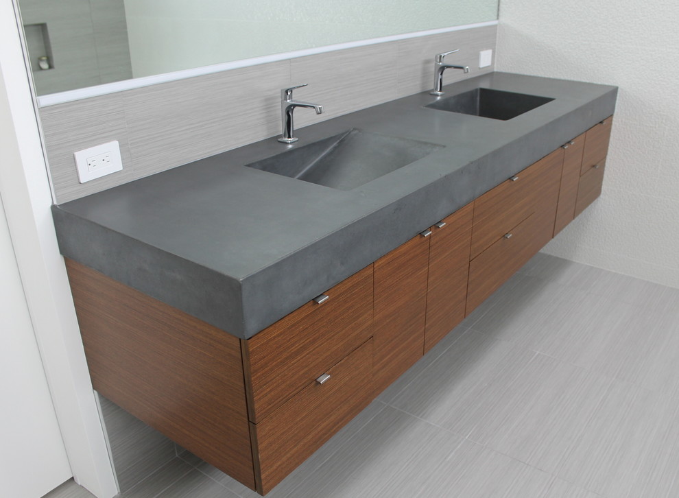 Photo of a large modern master bathroom in San Francisco with flat-panel cabinets, medium wood cabinets, concrete benchtops, gray tile, porcelain tile, an integrated sink, porcelain floors, grey walls, grey floor and grey benchtops.