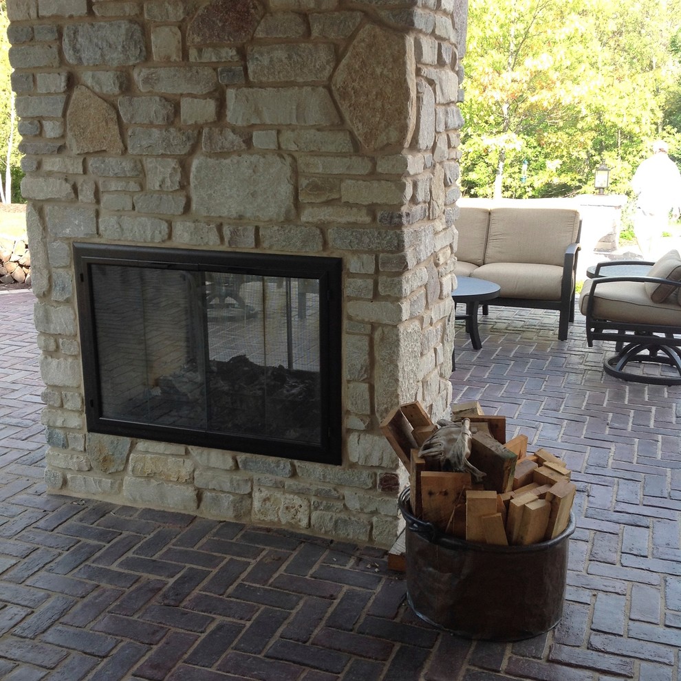 Example of a large mountain style backyard patio design with a roof extension