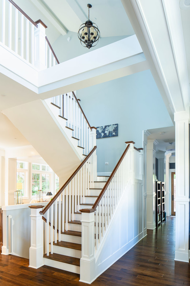 Large elegant wooden u-shaped wood railing staircase photo in Seattle with painted risers