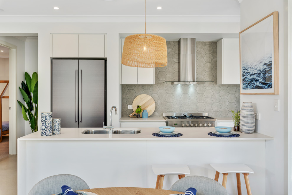 Design ideas for a beach style galley eat-in kitchen in Brisbane with an undermount sink, flat-panel cabinets, white cabinets, grey splashback, stainless steel appliances, concrete floors, a peninsula, grey floor and white benchtop.