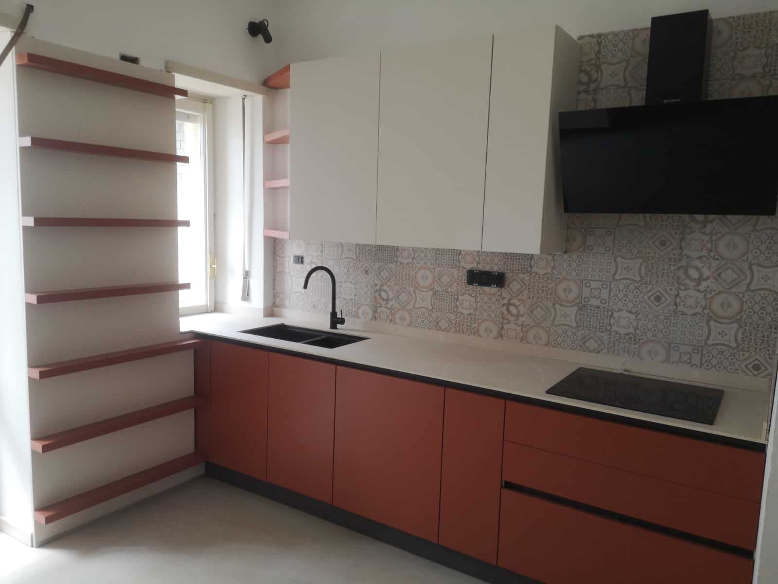 Cucina con Ante Laccate Opaco, Rosso Mattone per le basi e Vaniglia per i pensili e le colonne, maniglia a gola Brunito come lo zoccolo. Top in HPL finitura Cadice con lavello sottotop a 2 vasche in C