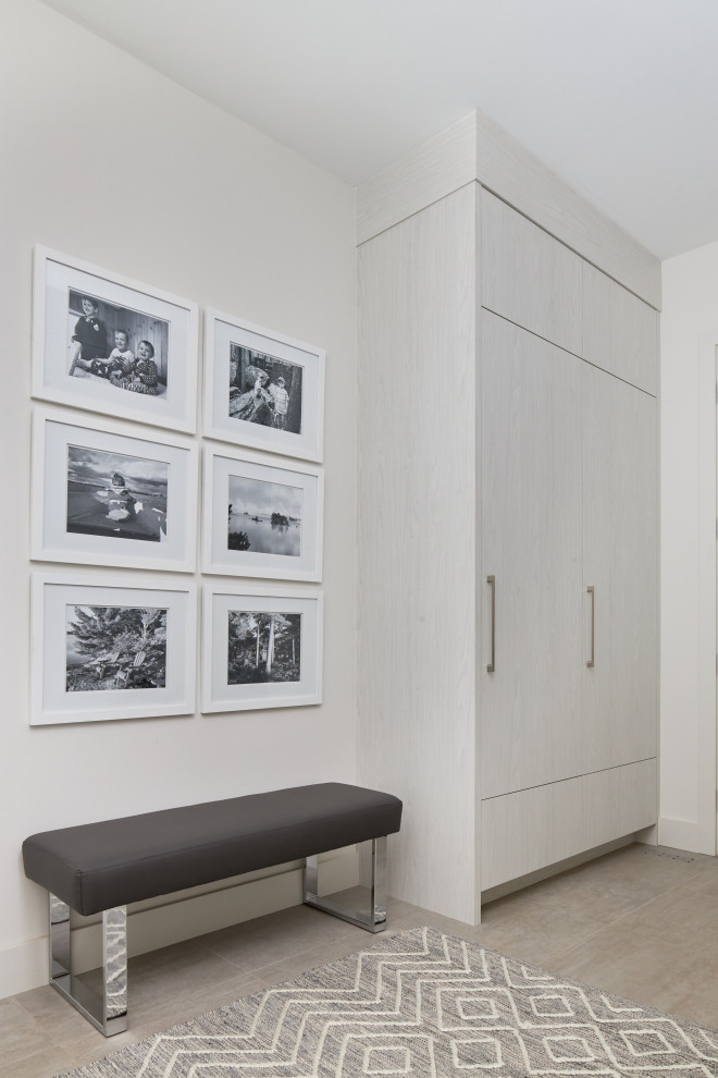 Mudroom - large modern porcelain tile mudroom idea with white walls
