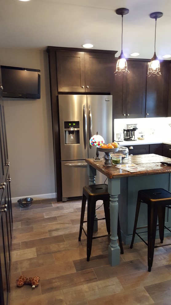 Eat-in kitchen - mid-sized rustic u-shaped porcelain tile eat-in kitchen idea in Indianapolis with a farmhouse sink, shaker cabinets, dark wood cabinets, wood countertops, white backsplash, ceramic backsplash, stainless steel appliances and an island