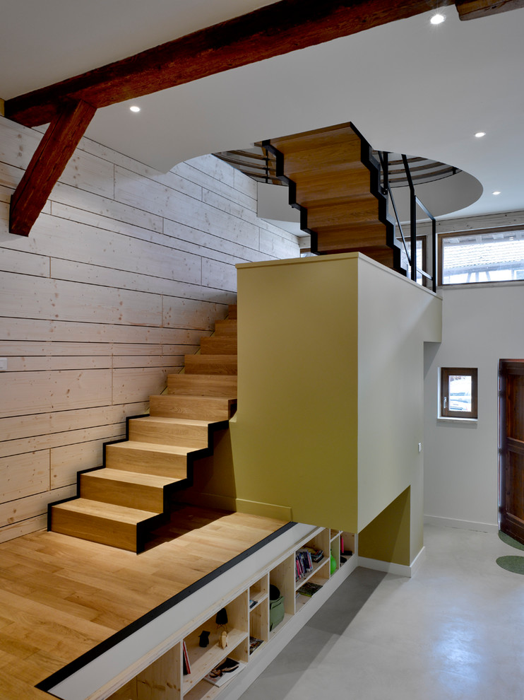 Inspiration for a contemporary wood u-shaped staircase in Strasbourg with wood risers and metal railing.