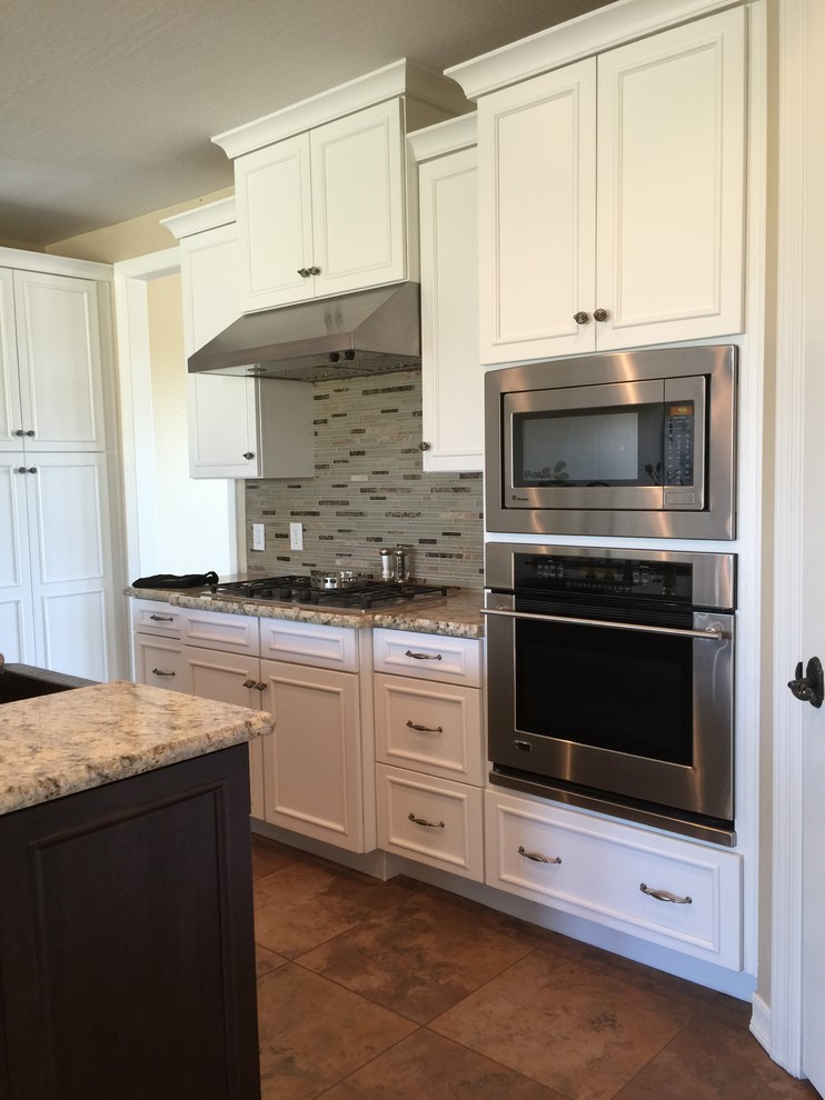 Inspiration for a large transitional eat-in kitchen remodel in Phoenix with granite countertops, gray backsplash, stone tile backsplash, black appliances and an island