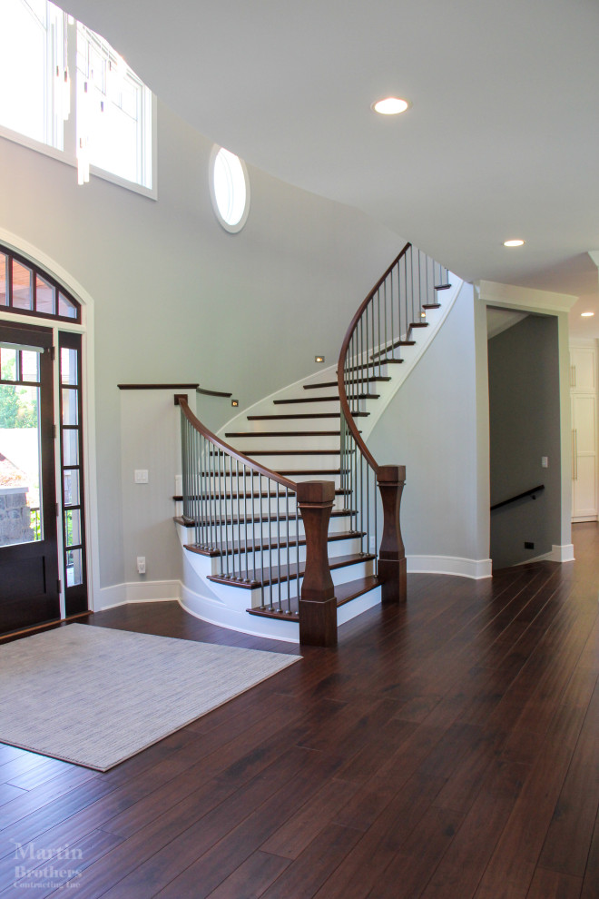 Large transitional dark wood floor and vaulted ceiling foyer photo with gray walls and a dark wood front door