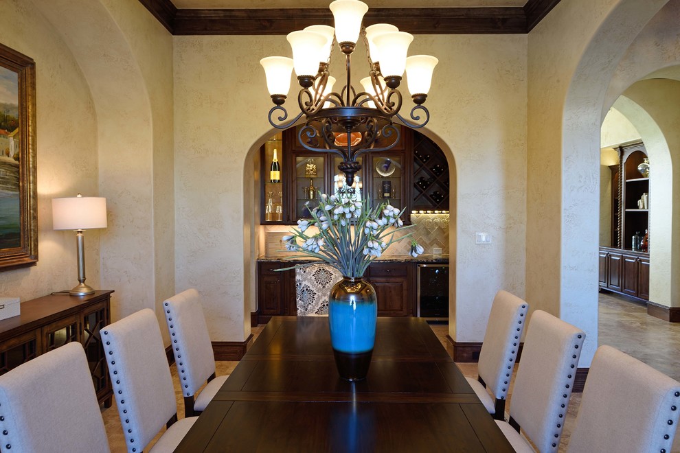 This is an example of a large mediterranean separate dining room in Houston with beige walls, travertine floors and beige floor.