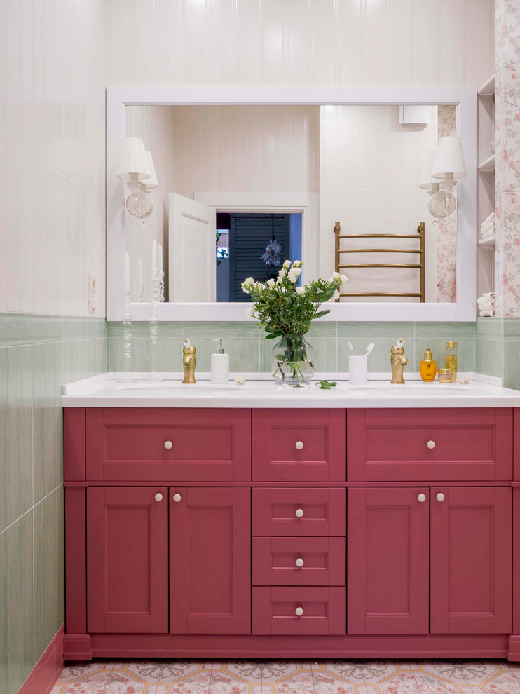 Inspiration for a mid-sized transitional kids bathroom in Other with raised-panel cabinets, red cabinets, an undermount tub, a wall-mount toilet, multi-coloured tile, ceramic tile, multi-coloured walls, ceramic floors, an undermount sink, solid surface benchtops, multi-coloured floor and white benchtops.
