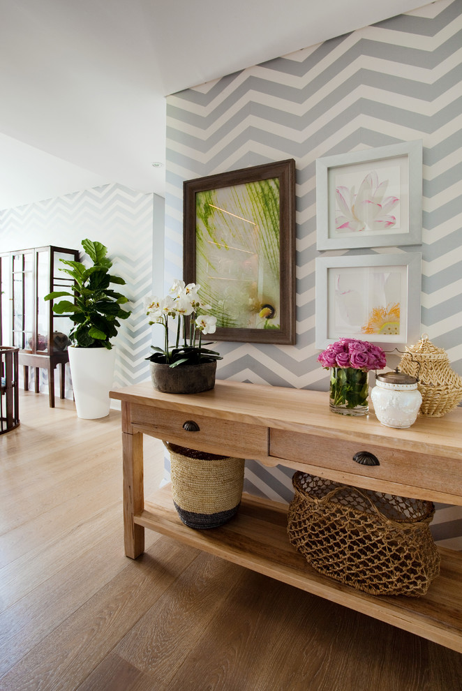 Design ideas for a mid-sized eclectic hallway in Sydney with multi-coloured walls and light hardwood floors.