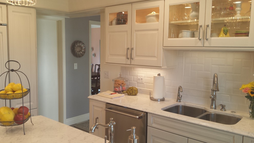 Inspiration for a small transitional u-shaped ceramic tile eat-in kitchen remodel with a double-bowl sink, raised-panel cabinets, white cabinets, marble countertops, white backsplash, subway tile backsplash, stainless steel appliances and an island