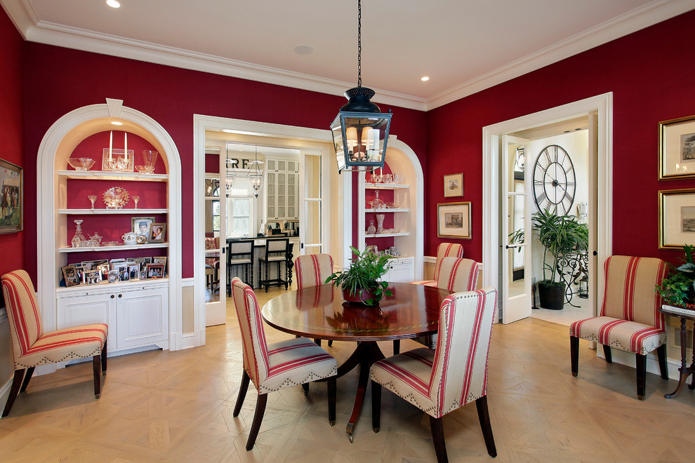 This is an example of a mediterranean separate dining room in Chicago with red walls and medium hardwood floors.