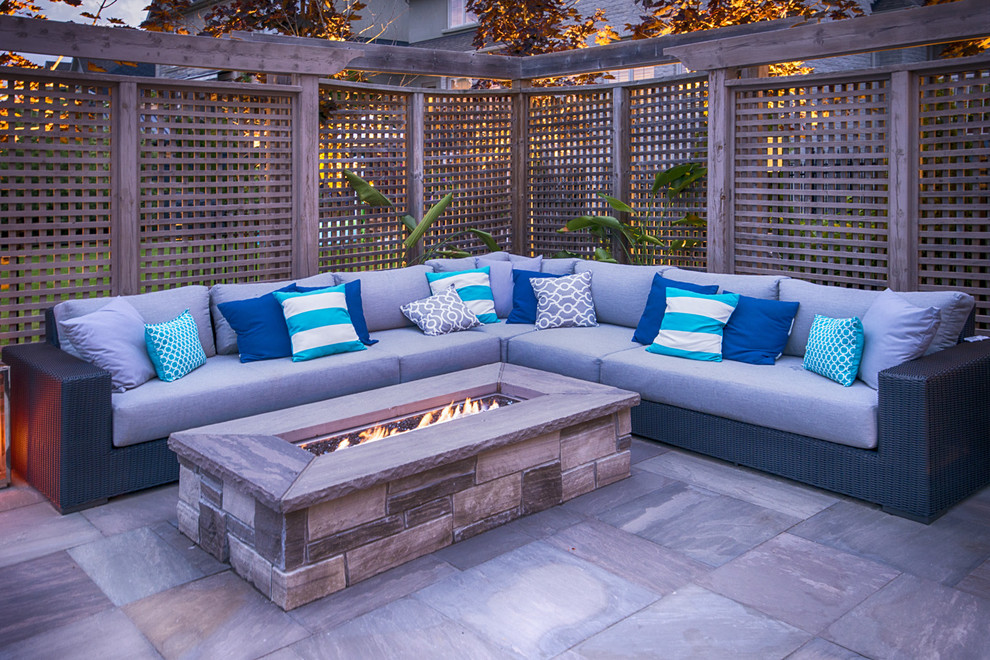 Mid-sized contemporary backyard patio in Toronto with natural stone pavers.
