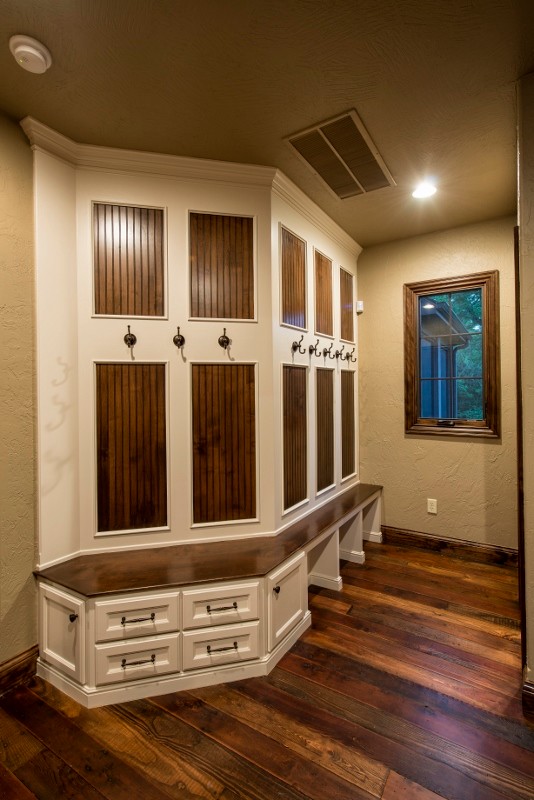 Photo of a large country mudroom in Other with beige walls and dark hardwood floors.